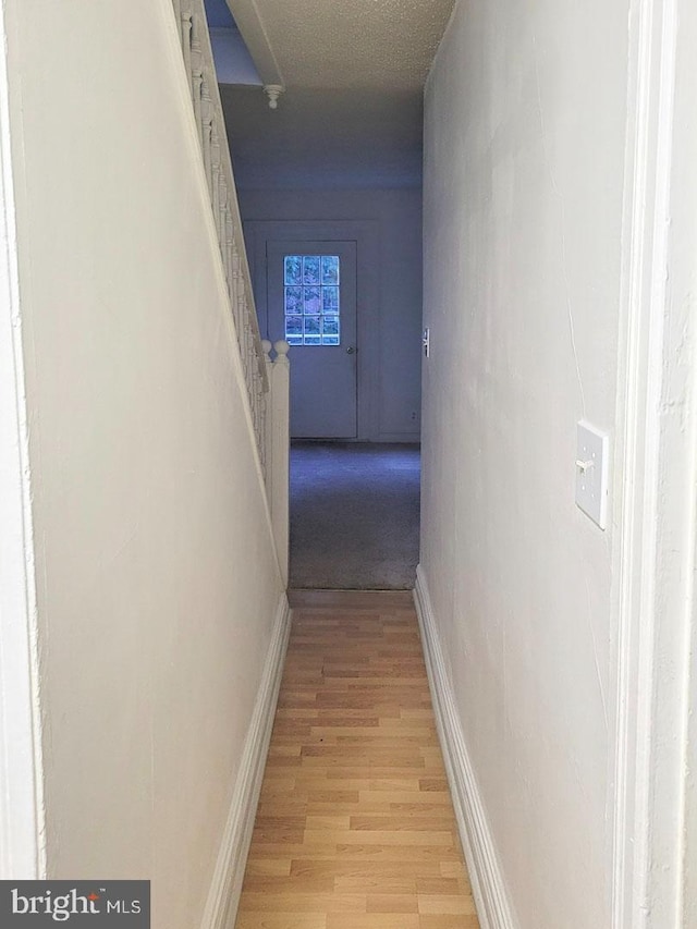 hall featuring baseboards and light wood-style floors