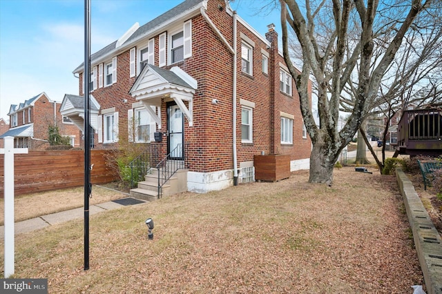 view of front of house featuring a residential view, brick siding, fence, and a chimney