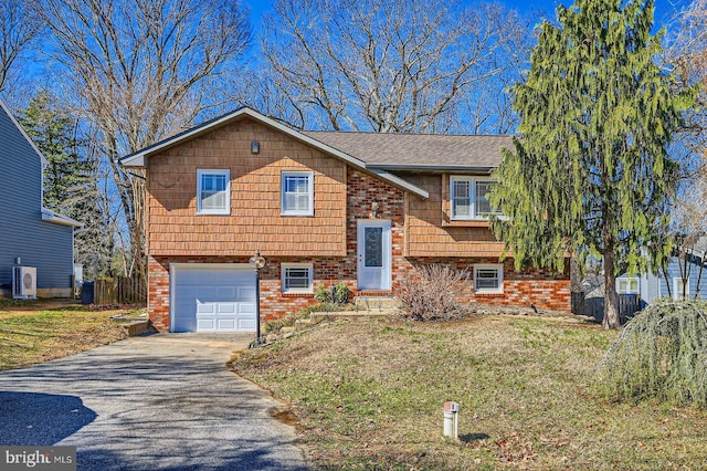 raised ranch featuring concrete driveway, brick siding, fence, and an attached garage