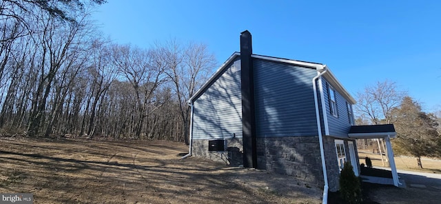 view of property exterior with central AC unit and a chimney