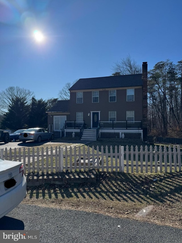 view of front of property with a fenced front yard and a chimney