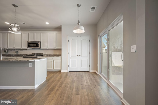 kitchen with visible vents, appliances with stainless steel finishes, light wood-type flooring, and a sink