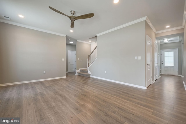 unfurnished living room featuring visible vents, stairway, baseboards, and wood finished floors