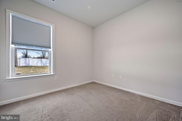 unfurnished room featuring carpet flooring and baseboards