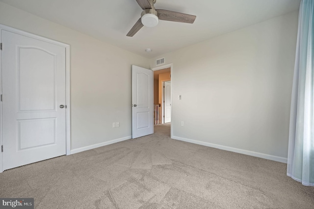 unfurnished bedroom with ceiling fan, carpet, visible vents, and baseboards