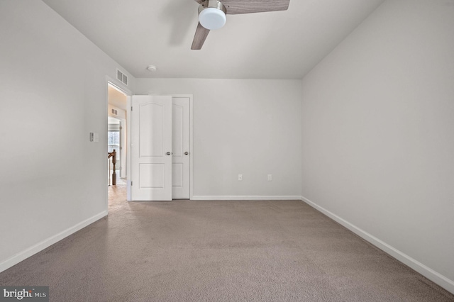 unfurnished room with visible vents, baseboards, carpet, and a ceiling fan