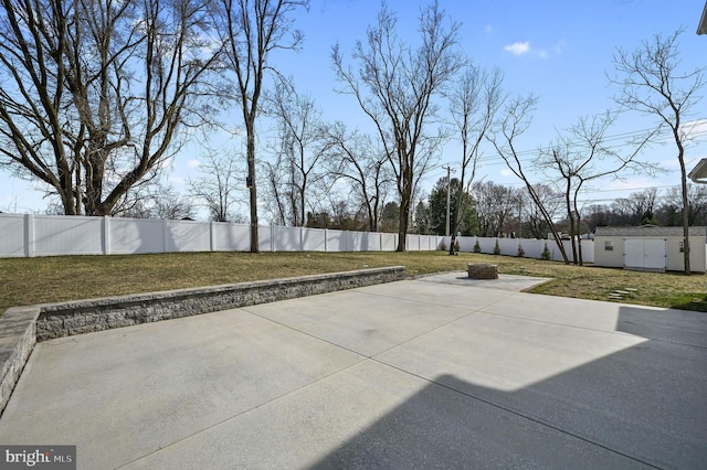 view of patio featuring an outdoor structure, a fenced backyard, a shed, and an outdoor fire pit