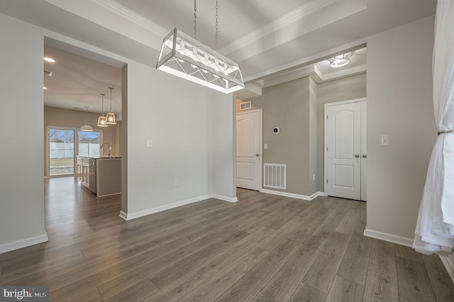 unfurnished dining area with a sink, visible vents, baseboards, and dark wood finished floors