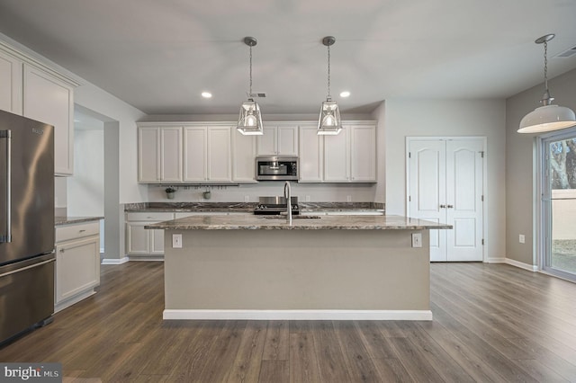 kitchen featuring stone counters, stainless steel appliances, and dark wood-style floors