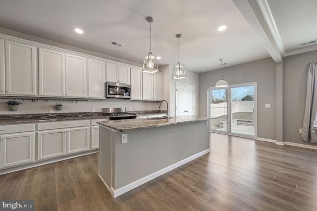 kitchen with visible vents, dark wood-type flooring, appliances with stainless steel finishes, stone countertops, and a sink