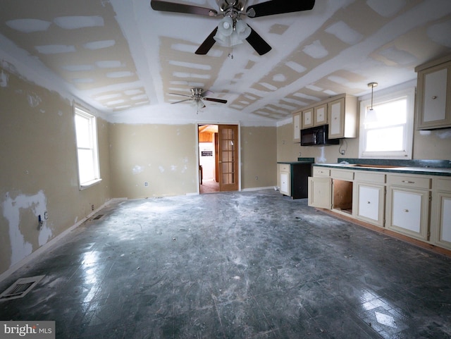 kitchen featuring visible vents, lofted ceiling, open floor plan, decorative light fixtures, and black microwave