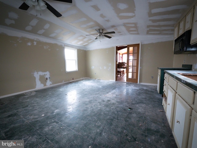 kitchen with black microwave, baseboards, vaulted ceiling, and open floor plan