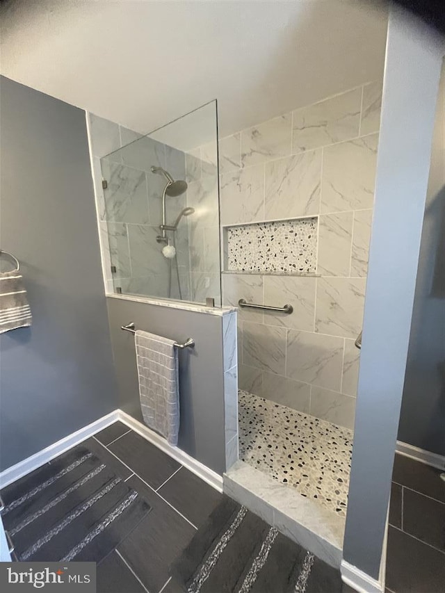 full bath with baseboards, a walk in shower, and tile patterned floors