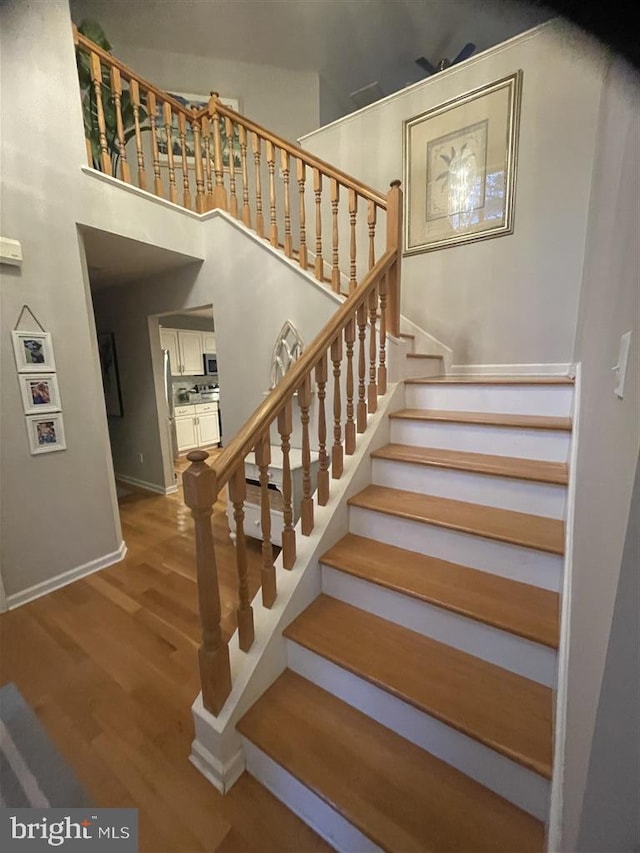 stairway with baseboards and wood finished floors