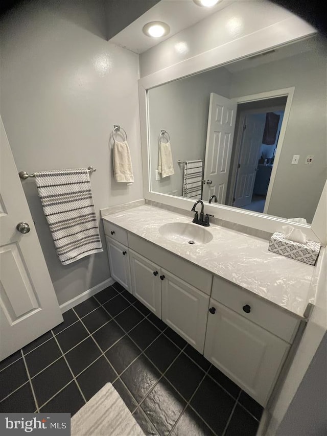 bathroom with tile patterned flooring, baseboards, and vanity