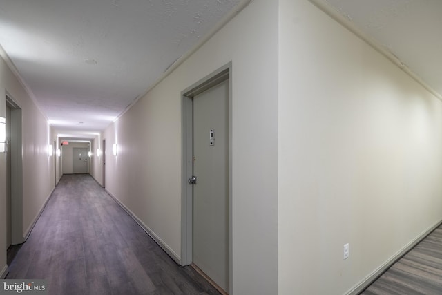 hall with baseboards and wood finished floors