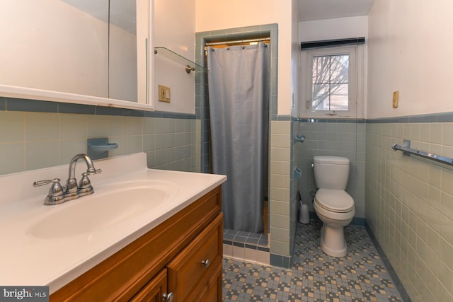 bathroom featuring a wainscoted wall, tile walls, toilet, a shower with curtain, and tile patterned floors