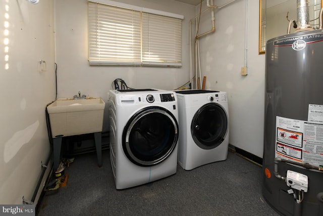 laundry area featuring baseboards, washer and clothes dryer, and gas water heater