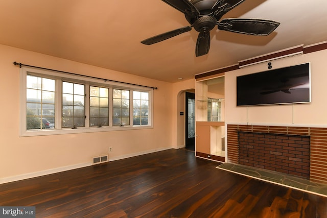 unfurnished living room with baseboards, visible vents, arched walkways, ceiling fan, and wood finished floors