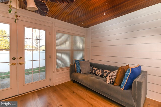 doorway to outside featuring wood ceiling, a healthy amount of sunlight, wooden walls, and wood finished floors