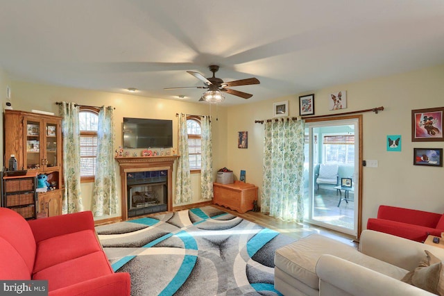 living area featuring a fireplace and ceiling fan