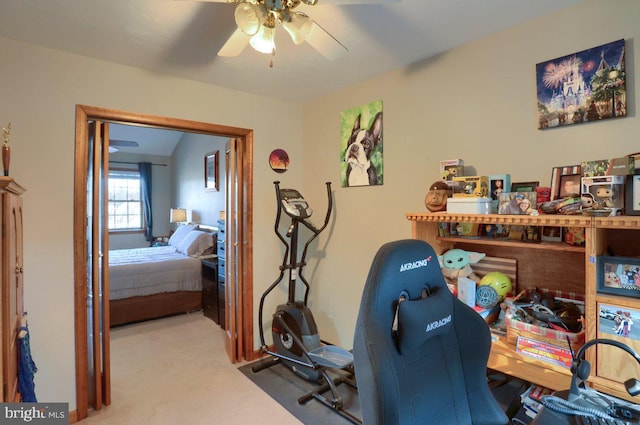 carpeted home office featuring ceiling fan