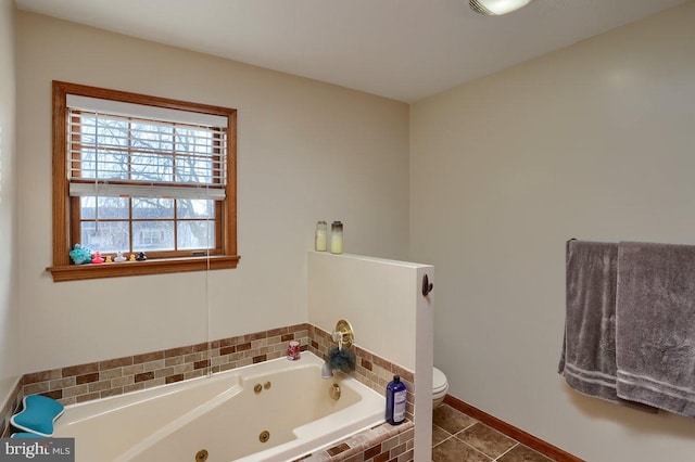 full bath with baseboards, toilet, a tub with jets, and tile patterned floors