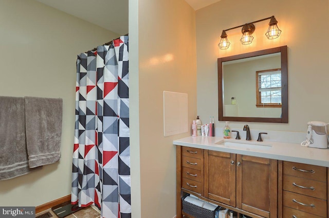 full bath featuring a shower with shower curtain, baseboards, and vanity