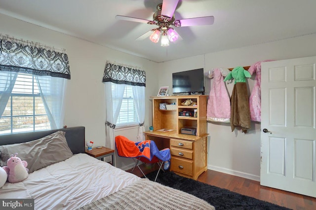 bedroom featuring ceiling fan, baseboards, and wood finished floors