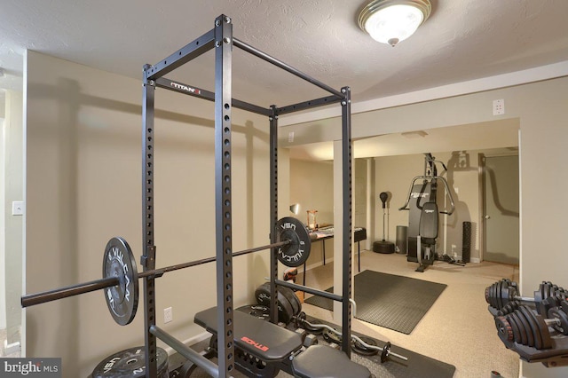 workout room with carpet flooring and a textured ceiling