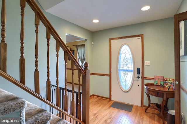 foyer entrance featuring baseboards, stairway, light wood-style flooring, and recessed lighting