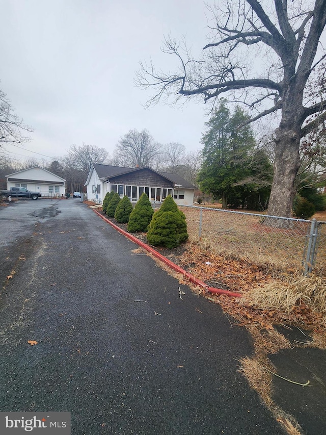 view of front of property with aphalt driveway and fence