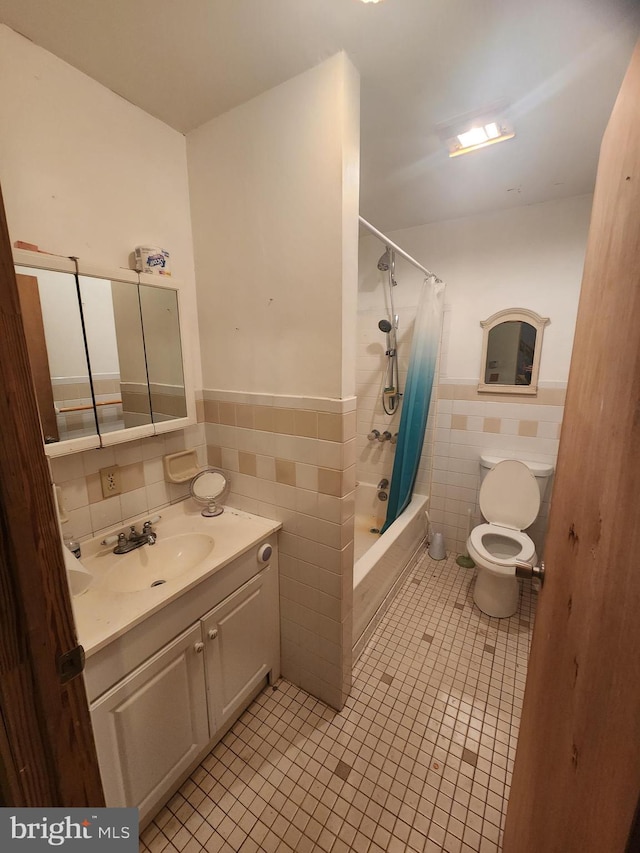 bathroom featuring toilet, vanity, tile walls, tile patterned floors, and shower / bath combo with shower curtain