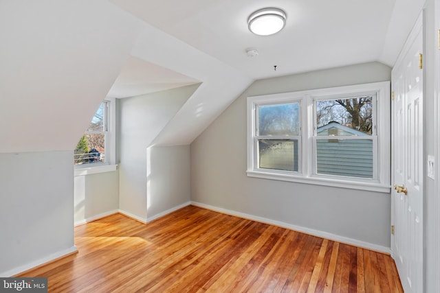 bonus room featuring baseboards, vaulted ceiling, and wood finished floors