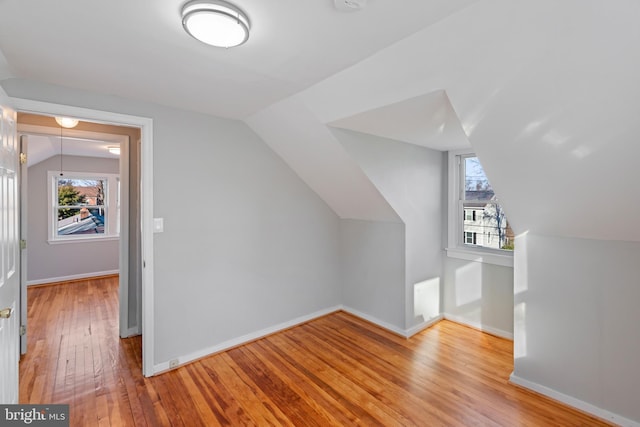 bonus room with a wealth of natural light, baseboards, and hardwood / wood-style flooring