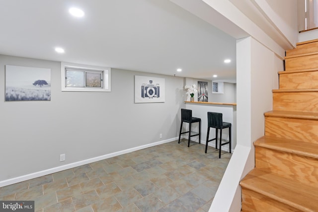 interior space with a bar, stairway, recessed lighting, and baseboards