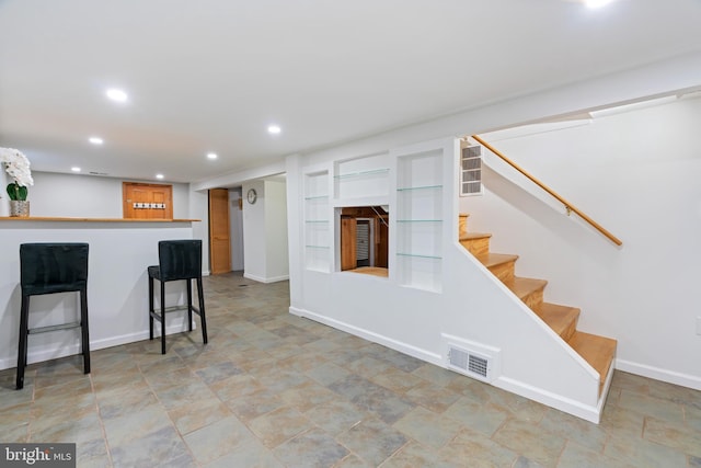 kitchen with recessed lighting, baseboards, visible vents, and a kitchen breakfast bar