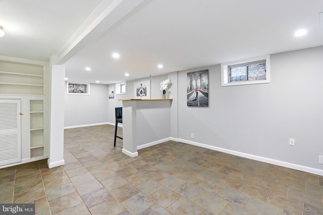 basement with baseboards, built in features, and recessed lighting