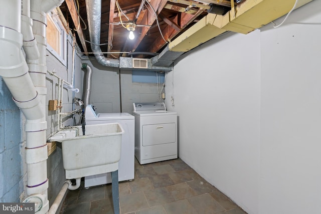 laundry area with visible vents, stone finish flooring, a sink, washer and dryer, and laundry area