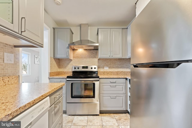 kitchen with appliances with stainless steel finishes, decorative backsplash, and wall chimney exhaust hood