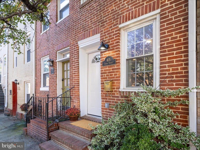 entrance to property featuring brick siding