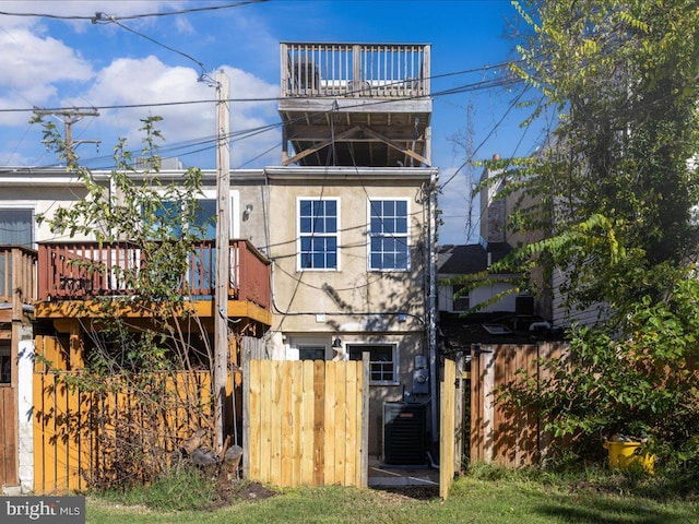 back of house featuring cooling unit, fence, and stucco siding