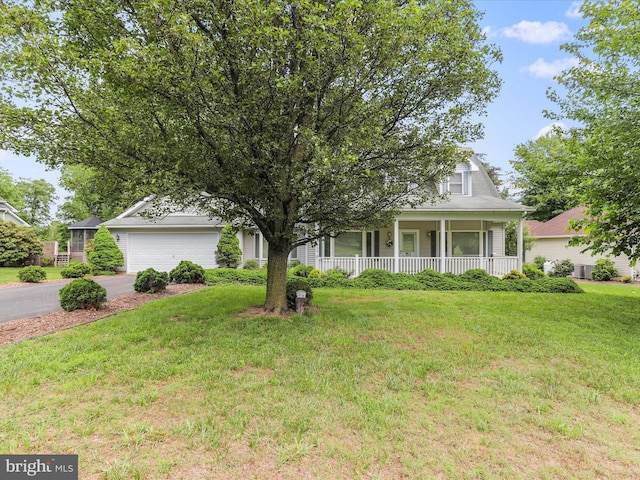 view of front of home featuring an attached garage, driveway, a front lawn, and a porch