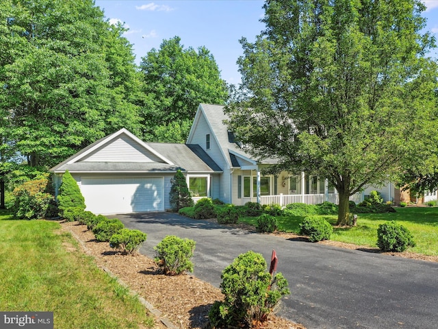 view of front facade featuring a garage, aphalt driveway, and a front yard