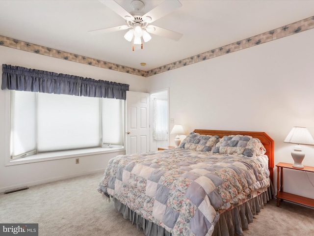 bedroom with ceiling fan, carpet flooring, visible vents, and baseboards