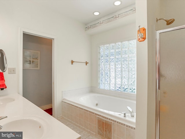 bathroom featuring double vanity, a stall shower, a garden tub, a sink, and recessed lighting