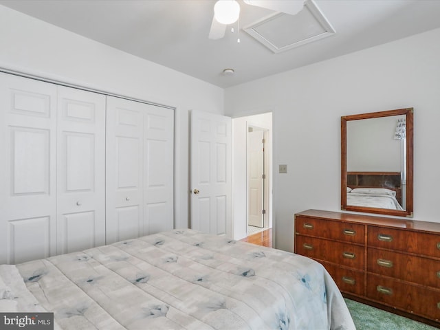 carpeted bedroom featuring attic access, ceiling fan, and a closet