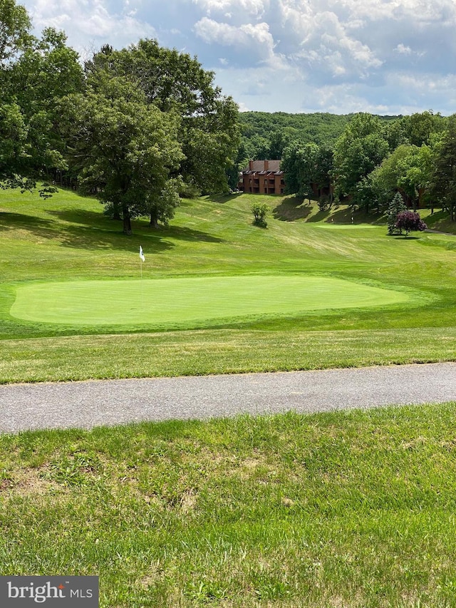 view of home's community featuring view of golf course and a lawn