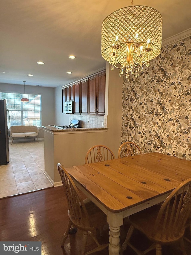 dining space featuring an inviting chandelier, light wood-style flooring, and recessed lighting