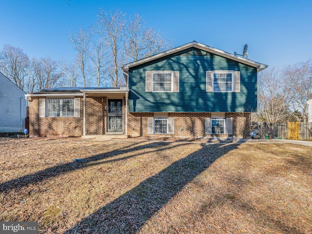 back of house featuring a yard and brick siding